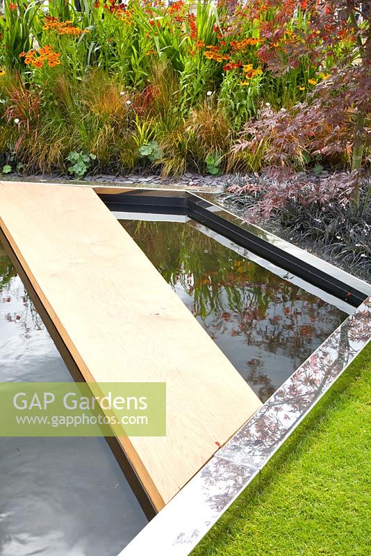 Garden pond with wooden pathway across 