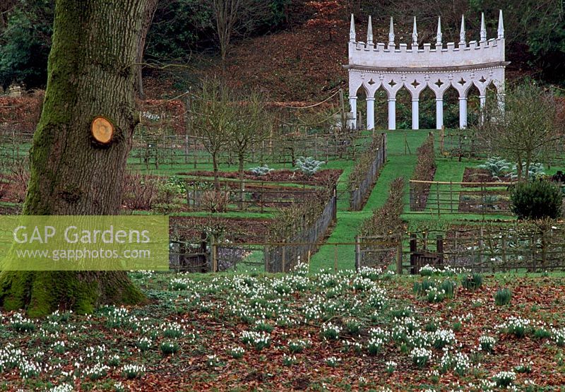 The Exedra, beyond geometrical vegetable gardens and snowdrops, at Painswick Rococo Garden, Painswick, Gloucestershire