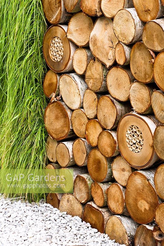 Grass and log wall with ladybird and insect house in The Porsche Garden, Gold Medalist - RHS Hampton Court Flower Show 2008