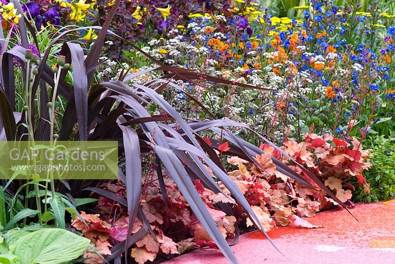 Phormium, Heuchera 'Marmalade' and Geum 'Fire Opal' - From Life to Life, A Garden for George - Chelsea Flower Show 2008