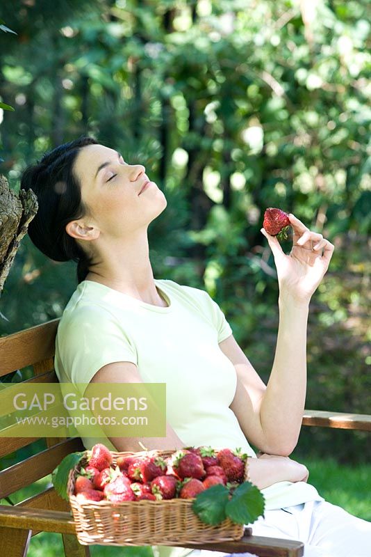 Woman sitting eating strawberries