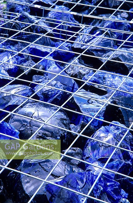 Metal gabion cube filled with large chucks of blue glass. WRAP 'The Recycled Garden', RHS Hampton Court Flower Show