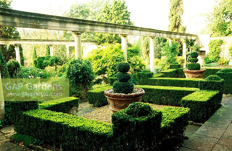 Behind the colonnade of the Great Terrace is a formal garden of box hedges framing pots from a villa near Siena - Iford Manor, Bradford-on-Avon, Wiltshire