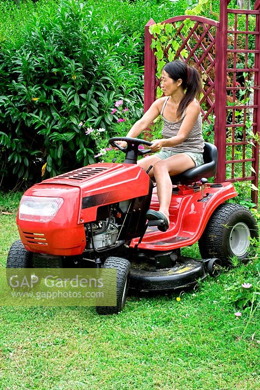 Woman on ride on lawn mower