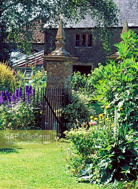 Mixed flowerbeds and gateway leading to house - Lower Severalls