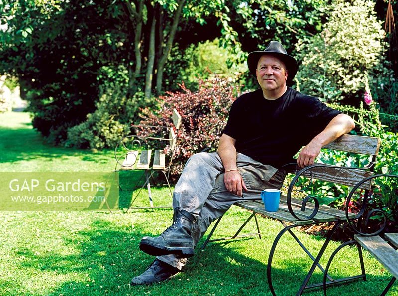 Man sat relaxing on garden bench - Lower Severalls