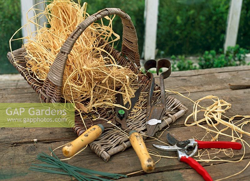 Collection of topiary clippers, shears and secataurs with raffia in a basket - River Garden Box Nursey