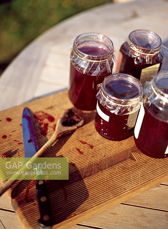 Jars of jam on chopping board on table