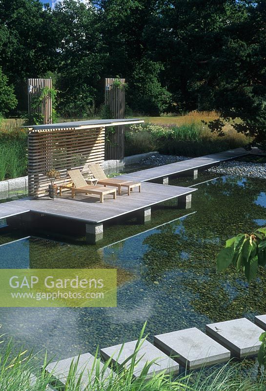 Contemporary garden with ponds, decked areas and sun loungers