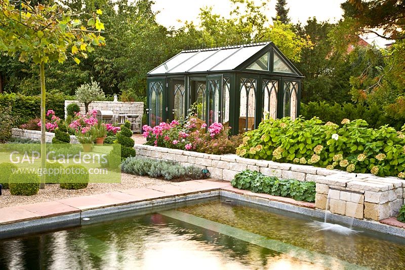 Mediterranean garden with pond and glass summerhouse