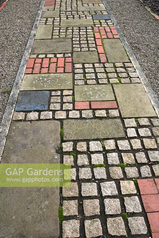 Patterned path made of reclaimed cobbles and tiles 