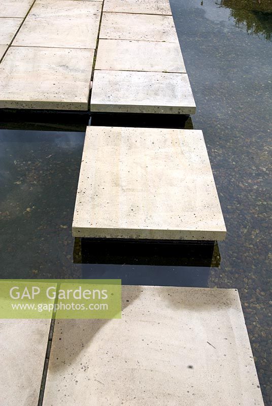 Rill lined with gravel and rectangular concrete stepping stone