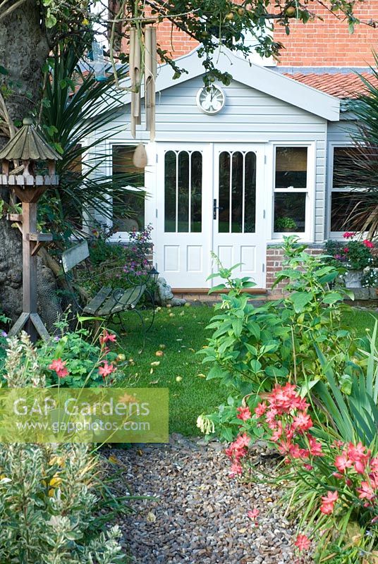 Painted garden room extension and autumn garden with Schizostylis coccinea
