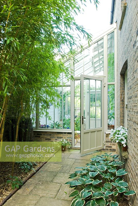 Lean to conservatory with Hostas, bamboos and rope top victorian edging tiles outside