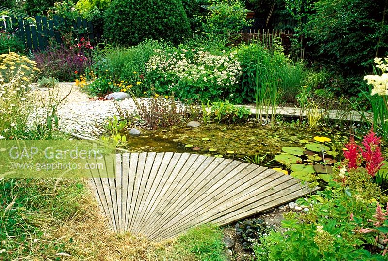 A radiating wooden platform reaches over this wildlife pond. There is plenty of foraging to be had in this wildlife friendly garden, Welwyn Garden City.