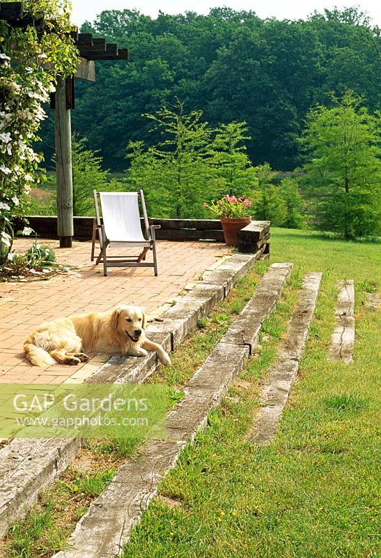 Railway sleepers define the terrace and steps in this French country garden