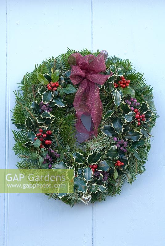 Pine foliage Christmas wreath with holly, red and purple berries