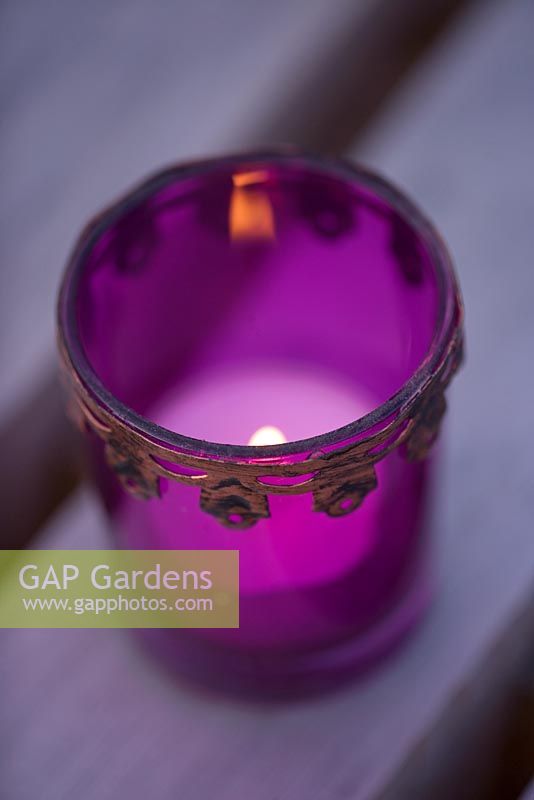 Ornate candle holder with lit candle on western red cedar bench - Roof garden, Holland Park, London 