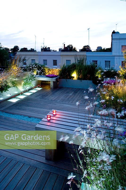 Decked terrace at night with led lighting and blue glass gravel - Roof garden, Holland Park, London