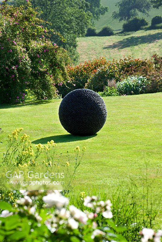 The Kernal sculpture on lawn in summer at Pettifers Garden, Oxfordshire