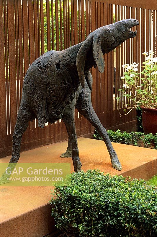 Corten steel predominates in this London garden, used here to screen the car parking area and as a platform for this bronze goat sculpture - Notting Hill Gate, London