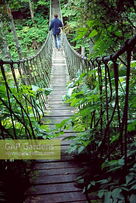 A rope bridge spans a deep ravine - Les Jardins de Quatre-Vents, Quebec