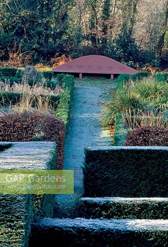 View over Yew hedges to the Grasses Parterre and seat - Veddw House Garden, February 