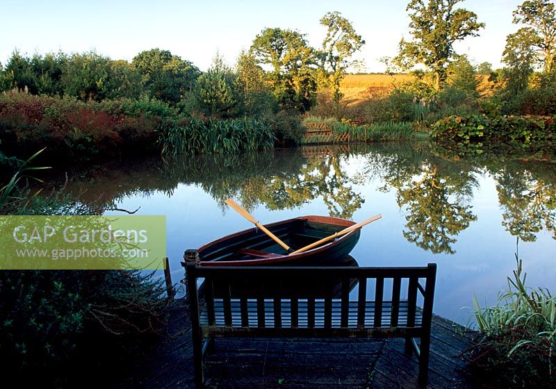 Seat overlooking lake with rowing boat -  Lady Farm, Chelwood, Somerset 