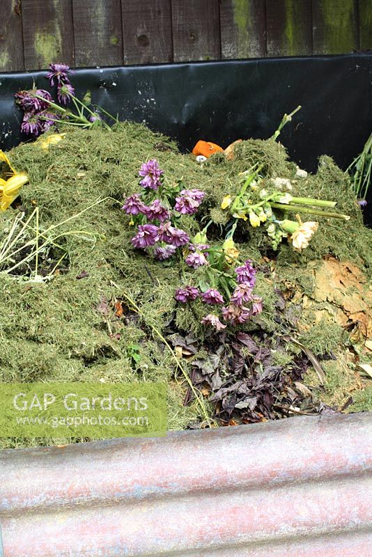 Compost heap with grass clippings, kitchen waste and spent flowers