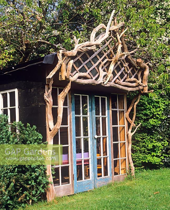 Rustic summerhouse decorated with recycled fallen timber - Charlotte Molesworth's garden, Kent