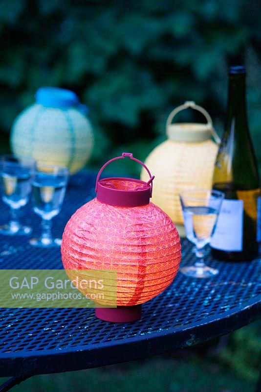 Coloured lanterns and glasses on a garden table