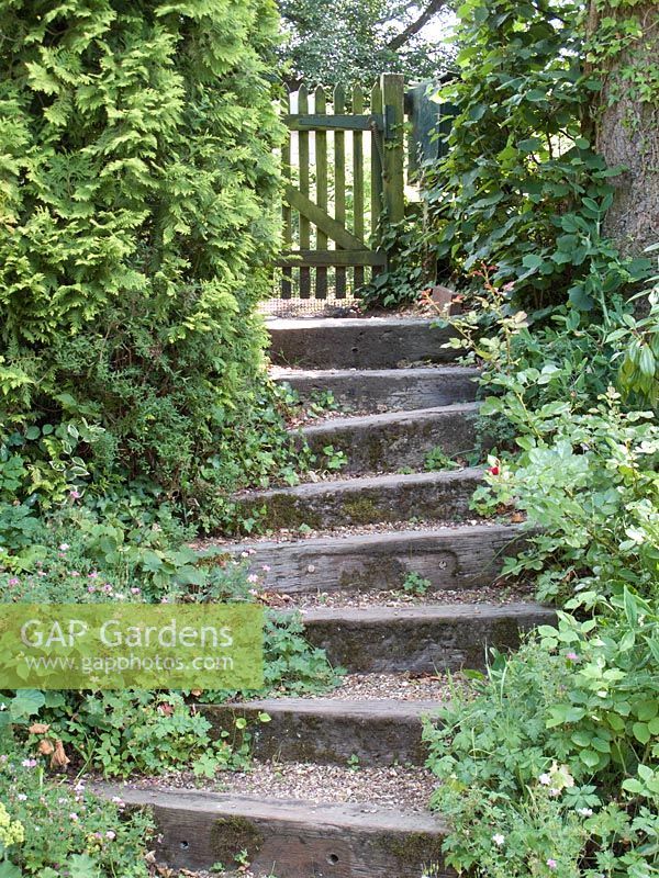 Railway sleepers and shingle steps leading to a wooden garden gate