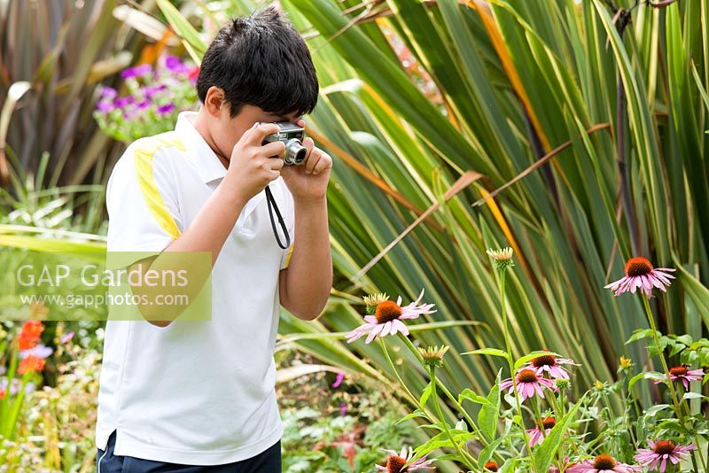 Young boy photographing flowers