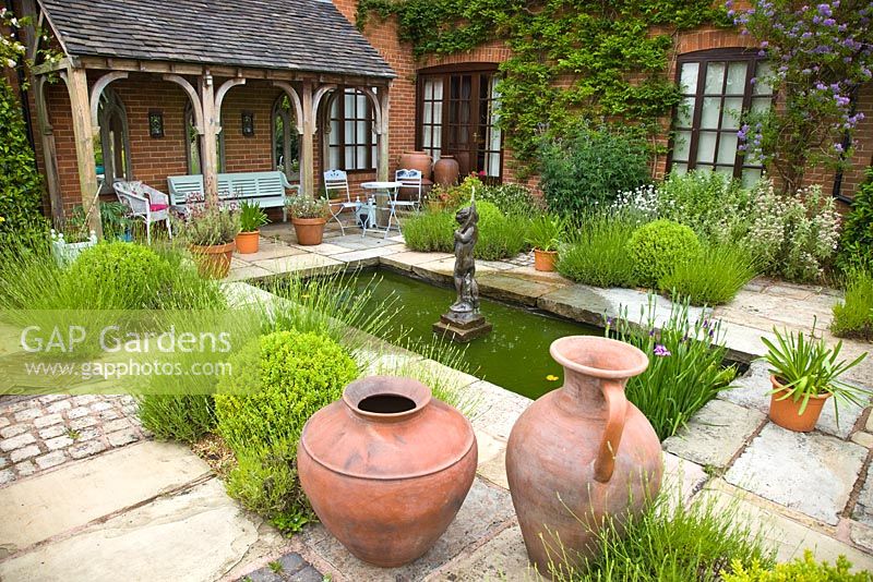 Patio area with pond and fountain, seating area with plantings of aromatic lavender and terracotta pots and containers - Wilkins Pleck, NGS, Whitmore near Newcastle-under-Lyme in North Staffordshire 