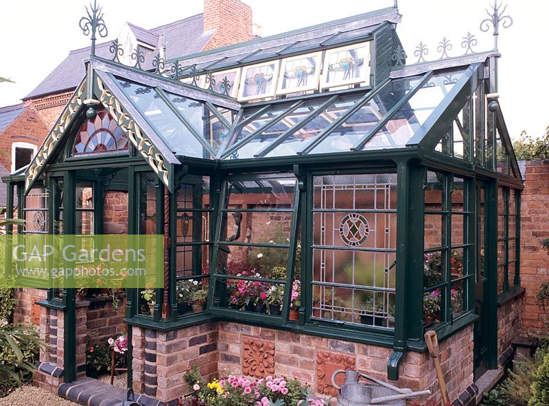 DIY greenhouse project. 1 of 12,  built from recycled stained glass windows, stairway spindles, salvaged bricks and terracotta plaques to a classic Victorian design to match the architecture of the house