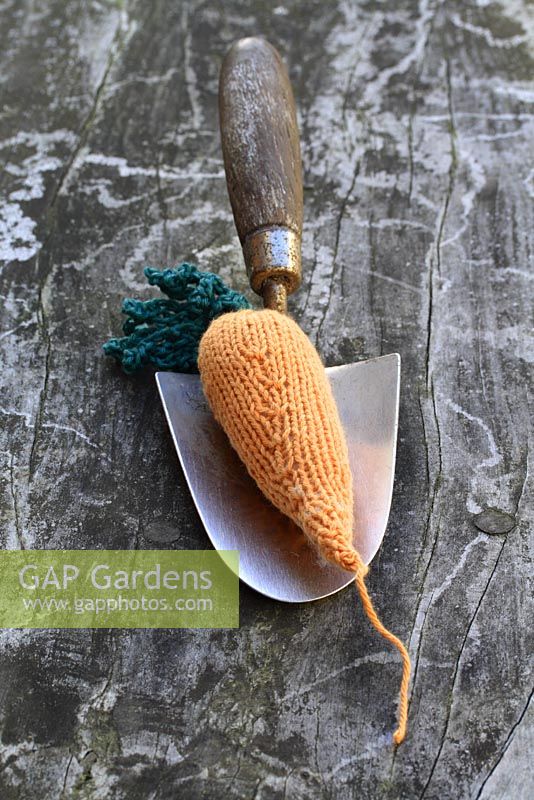 Knitted carrot on a trowel