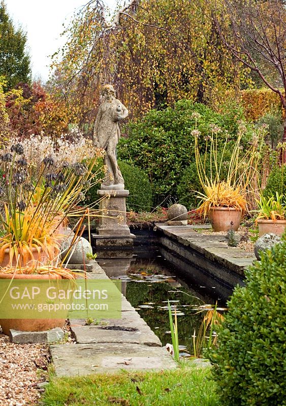 Canal garden with terra cotta pots and statuary in autumn at Wilkins Pleck (NGS) Whitmore near Newcastle-under-Lyme in North Staffordshire