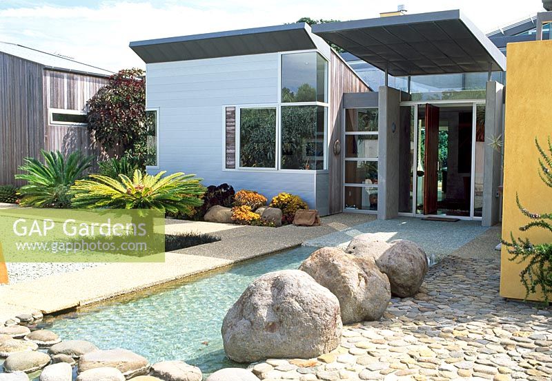 Stylised nature including river and boulders, complete the front entrance to this art collector's home. Planting is tropical including Cycads - Waiheke, New Zealand