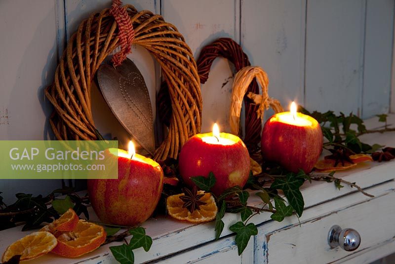 Apples used as tea-light or candle holders decorated with Ivy, dried orange slices and Star Anise.