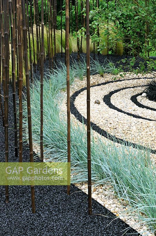Contrasting circles of crushed black basalt and gravel with planting of Bamboo and Elymus magellanicus. Design - Sheena Seeks. RHS Tatton park flower show