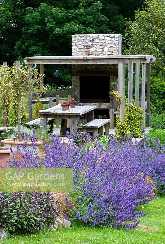 Outdoor kitchen with pizza oven and large dining table - Clare Matthews garden, Devon