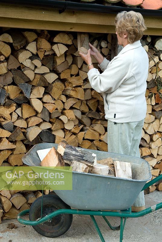 Woman collecting firewood from store