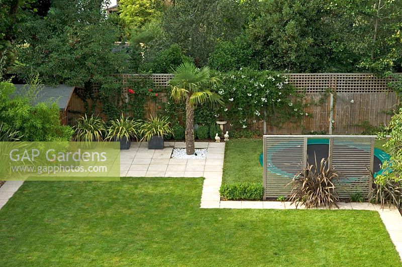 Contemporary urban garden with kids play area, astro turf lawn and mixed planting - London