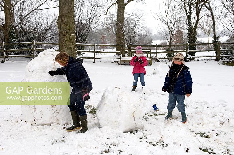 Children building snowman. Pannells Ash Farm, Essex, February.