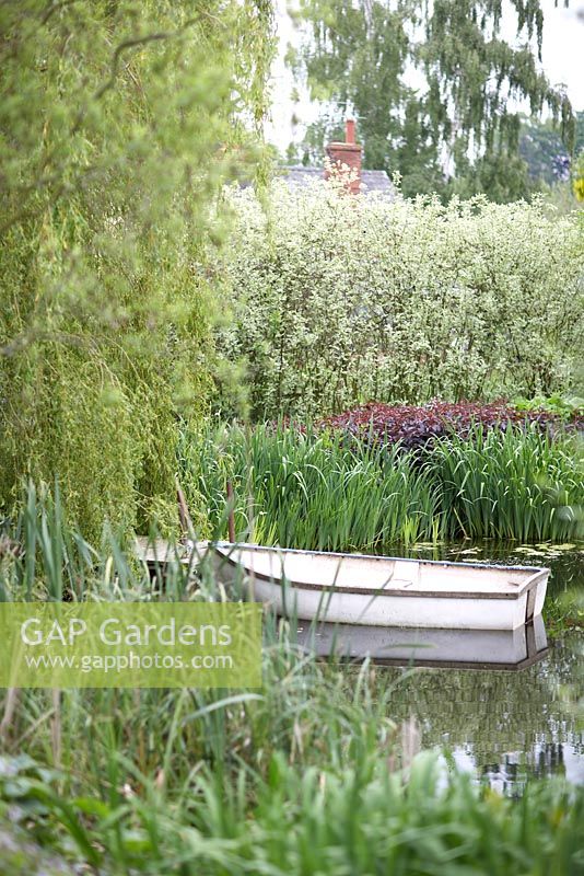 Westonbury Mill Water Gardens with boat on water near weeping willow