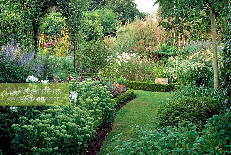 Formal garden divided into geometric beds edged with box to maximise space