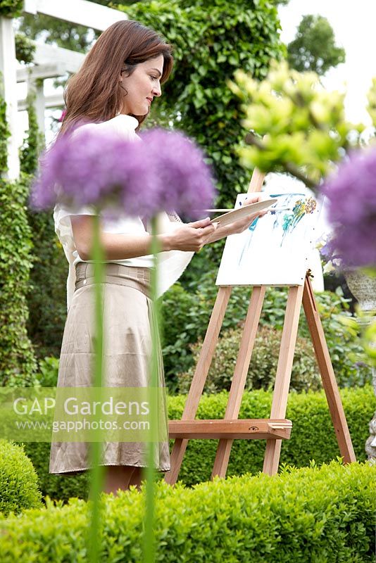 Woman painting in garden 