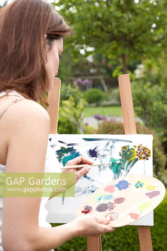Woman painting in a garden