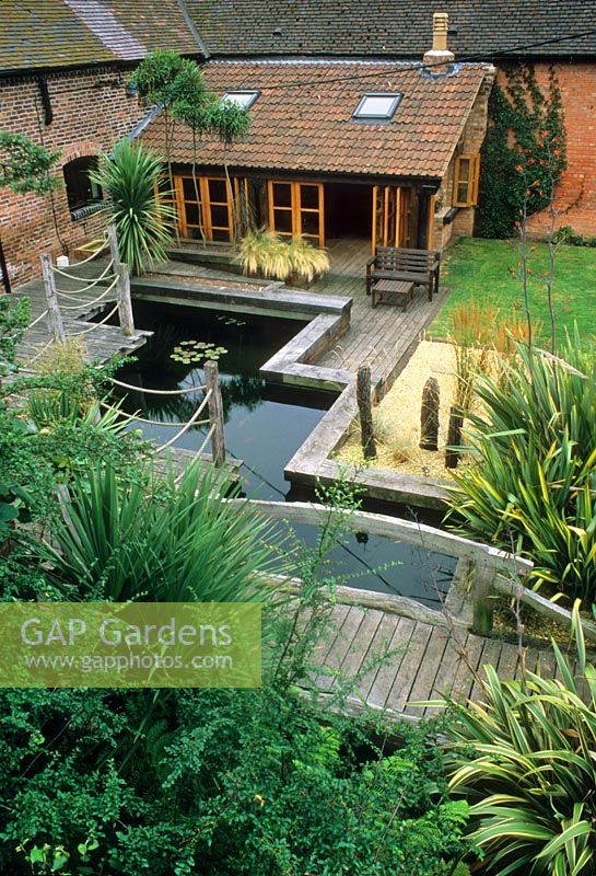 Contemporary design of courtyard garden with decking and barn conversion 
