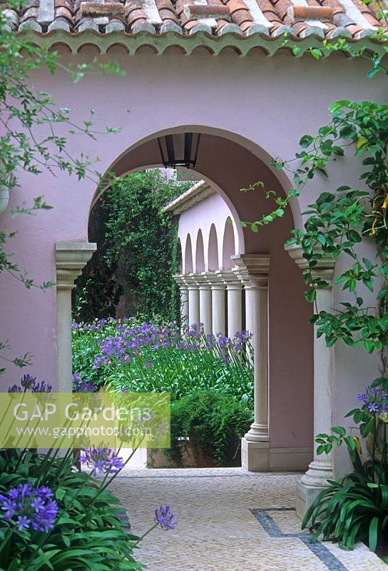 Mediterranean courtyard garden with Agapanthus and cobble stone path. Quinta do Convento Da Trindade, Portugal